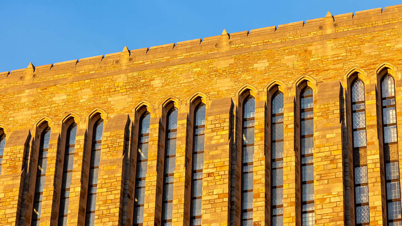 Sunlight on Yale University building with tall arched windows