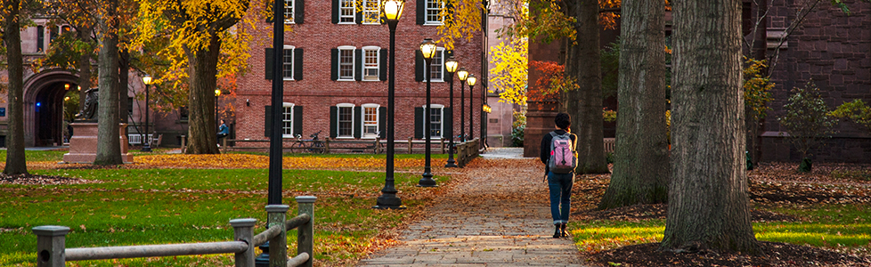 Student walking on Old Campus in the fall